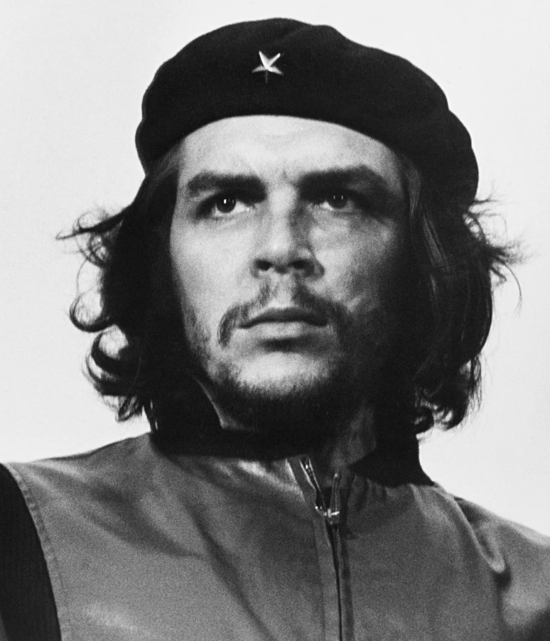 A black and white portrait of a man wearing a beret with a star, featuring long hair and a serious expression.