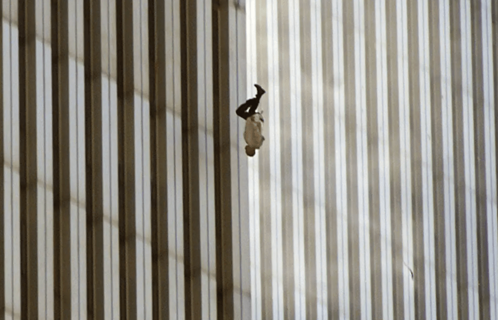 A person hanging from the side of a tall building with vertical stripes.