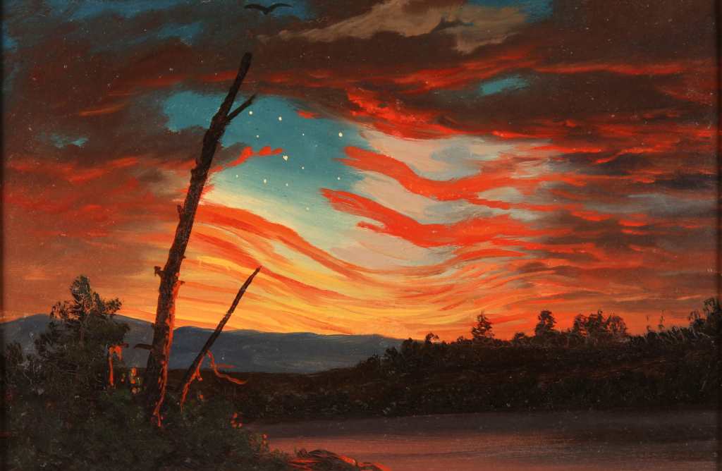 A vibrant sunset over a lake, featuring dramatic red and orange clouds, with a silhouette of a tree in the foreground.